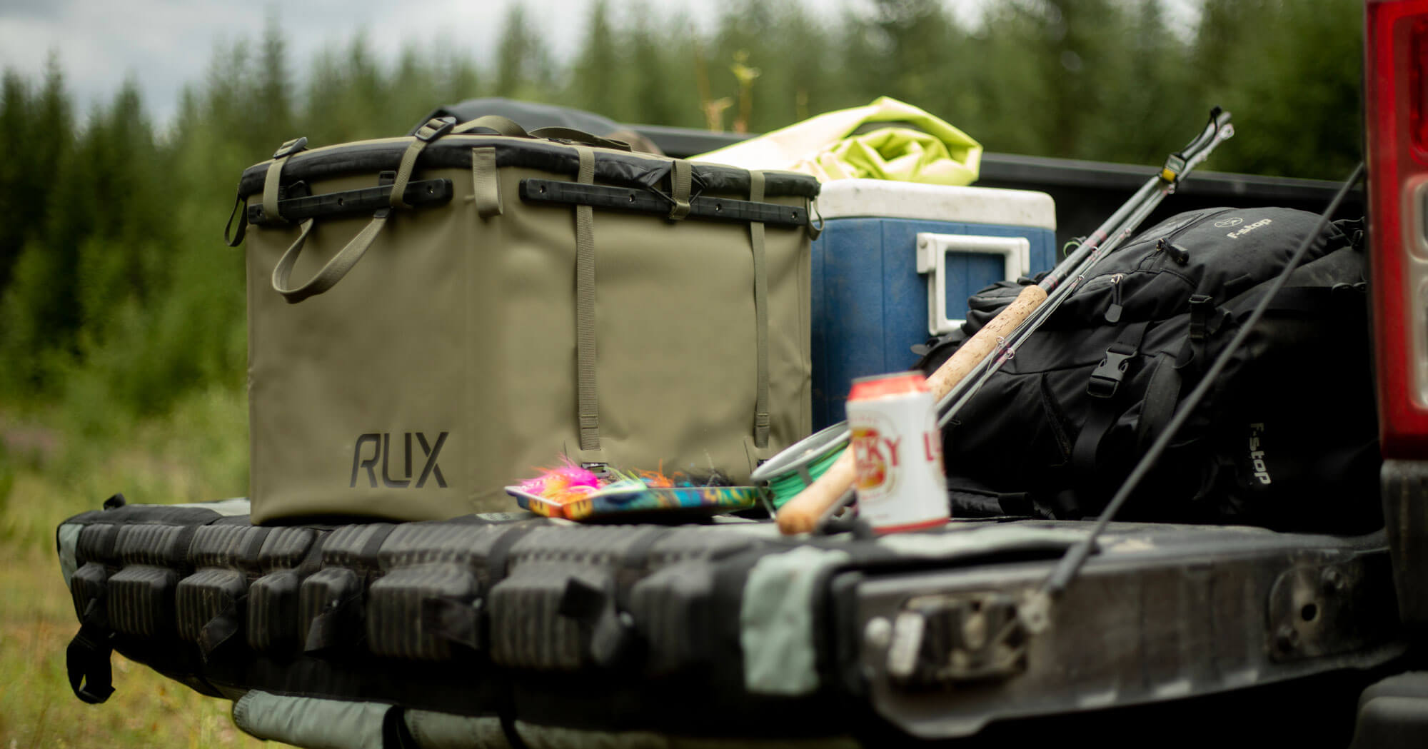 RUX 70L on a truck bed with fishing gear. 